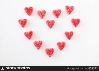 Jelly (gummy) sugar coated candy hearts arranged in the shape of a heart. Isolated on white.