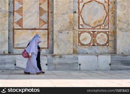 JERUSALEM, ISRAEL - APRIL 30, 2015: Arab women with veil walk beside the mosque Dome of the Rock