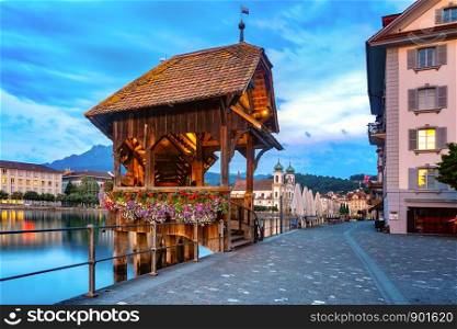 Jesuit Church and Chapel Bridge, Kapellbrucke over the river Reuss during evening blue hour in Old Town of Lucerne, Switzerland. Lucerne in the evening, Switzerland