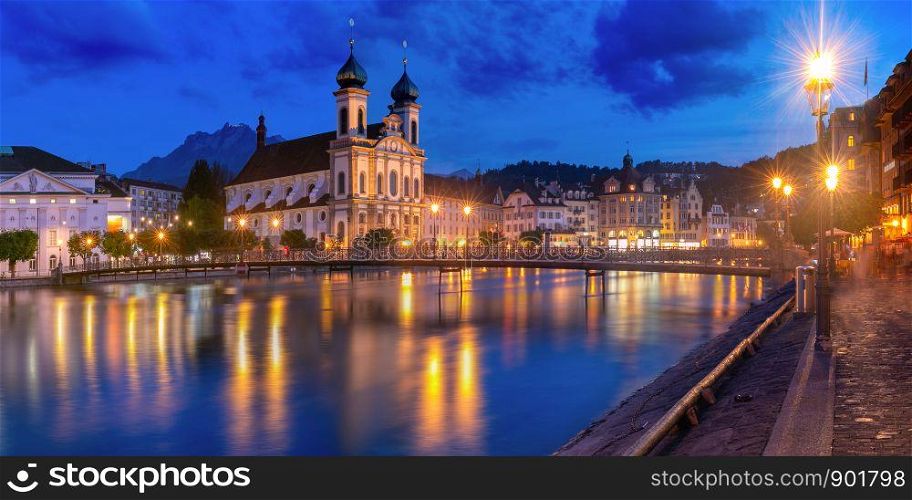 Jesuit Church and fairy tale houses along the river Reuss at night in Old Town of Lucerne, Switzerland. Lucerne at night, Switzerland