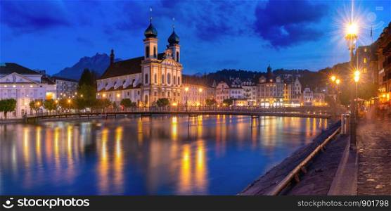 Jesuit Church and fairy tale houses along the river Reuss at night in Old Town of Lucerne, Switzerland. Lucerne at night, Switzerland