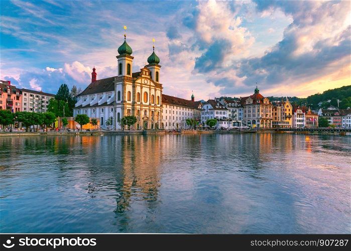 Jesuit Church and fairy tale houses along the river Reuss at sunset in Old Town of Lucerne, Switzerland. Lucerne at sunset, Switzerland