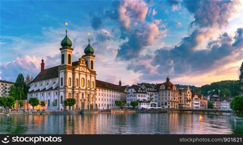 Jesuit Church and fairy tale houses over the river Reuss at sunset in Old Town of Lucerne, Switzerland. Lucerne at sunset, Switzerland