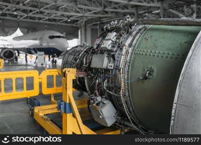 Jet airplane turbine on repairing in hangar, plane engine without covers on maintenance, nobody. Air transportation safety concept. Jet airplane turbine on repairing in hangar