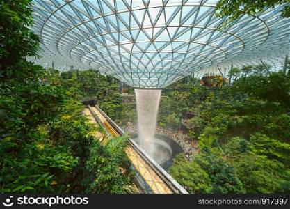 Jewel Changi Airport in Singapore City. Interior design decoration with waterfall, garden and trees. The world's best airport and destination