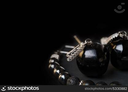 jewel handmade bracelet with semipreciouse stones and earrings with black semiprecious gem jet at black background