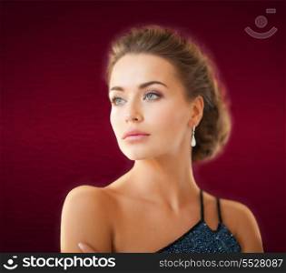 jewelry and beauty concept - beautiful woman in evening dress wearing diamond earrings