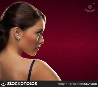 jewelry and beauty concept - beautiful woman in evening dress wearing diamond earrings