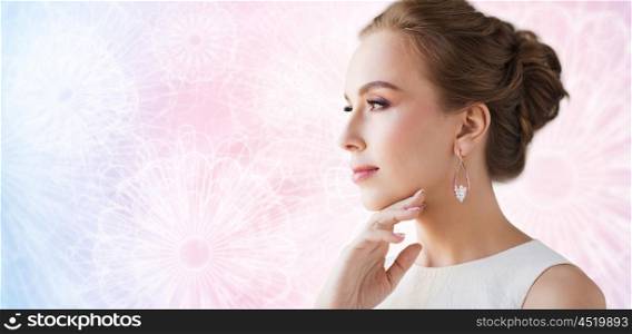 jewelry, luxury, wedding and people concept - smiling woman in white dress wearing pearl earring over rose quartz and serenity patterned background
