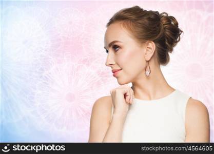 jewelry, luxury, wedding and people concept - smiling woman in white dress wearing pearl earrings over rose quartz and serenity pattern background
