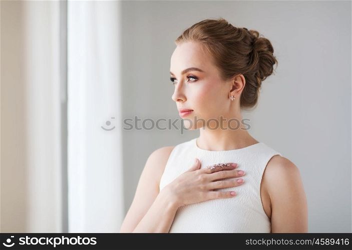 jewelry, luxury, wedding and people concept - smiling woman in white dress with diamond earring and ring