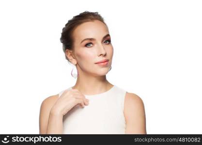 jewelry, luxury, wedding and people concept - smiling woman in white dress wearing pearl earrings over white background