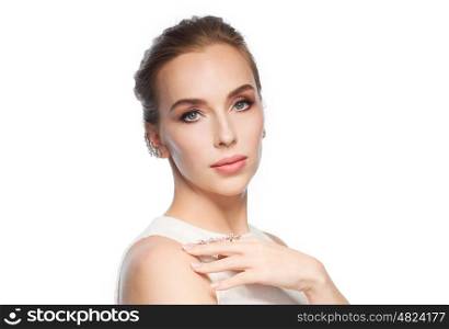 jewelry, luxury, wedding and people concept - smiling woman in white dress with diamond earring and ring over white background