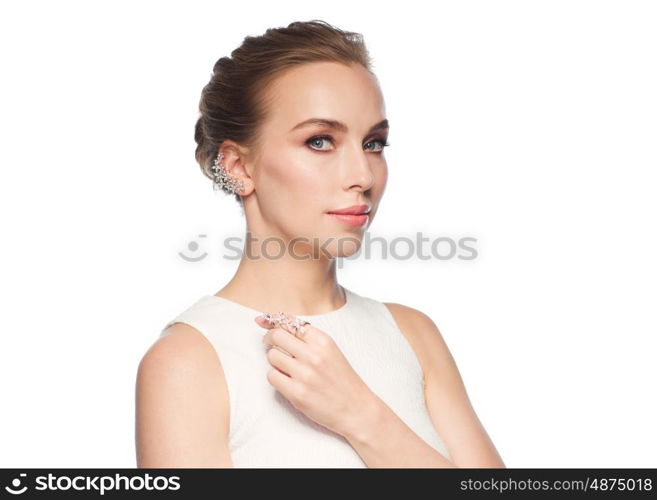 jewelry, luxury, wedding and people concept - smiling woman in white dress with diamond earring and ring over white background