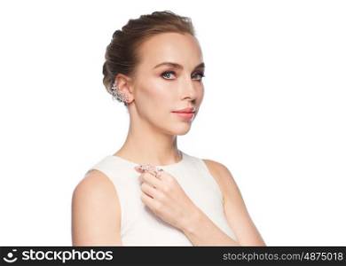 jewelry, luxury, wedding and people concept - smiling woman in white dress with diamond earring and ring over white background
