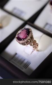 jewelry retail store showcase displaying white gold ring with precious gemstones. ring with huge ruby and diamonds. close up