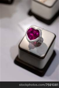 jewelry retail store showcase displaying white gold ring with precious gemstones. ring with huge turmaline and diamonds. close up