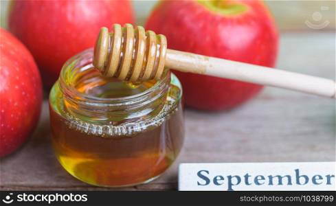 Jewish holiday, Apples Rosh Hashanah on the photo have honey in jar and red apples on wooden background