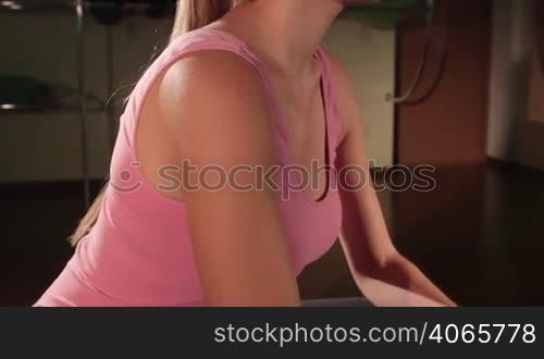 JIB CRANE: Fit woman working out in gym with light weight dumbbells closeup