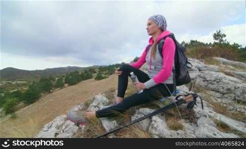 JIB CRANE: Fit young woman day hiker on the top of mountain yayla looking at plateau Ai-Petri
