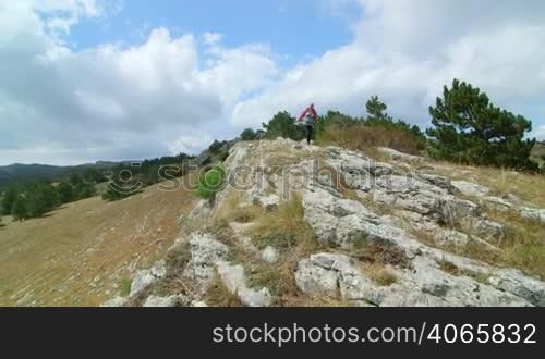 JIB CRANE: Woman day hiking highlands walking along bare stone plateau Ai-Petri