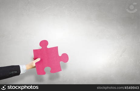 Jigsaw elements in hand. Human hand holding in palm puzzle elements