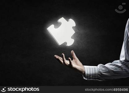 Jigsaw elements in palms. Human hand holding in palm puzzle glowing element