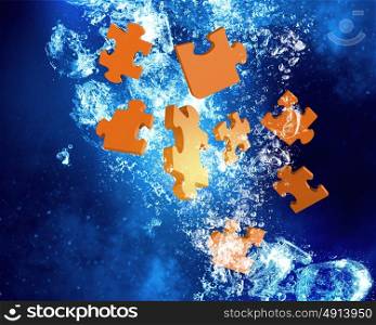 Jigsaw elements under water. Puzzle elements sink in clear blue water