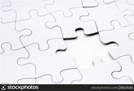 Jigsaw puzzle in white with a missing piece