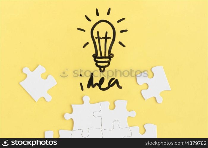jigsaw puzzle light bulb with idea word yellow background