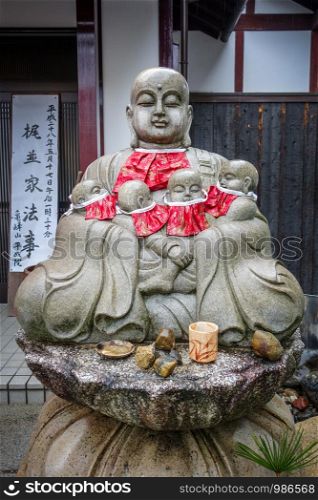 Jizo statue with red bibs in Arashiyama temple, Kyoto, Japan. Jizo statue in Arashiyama temple, Kyoto, Japan