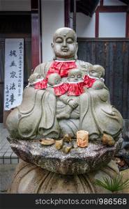 Jizo statue with red bibs in Arashiyama temple, Kyoto, Japan. Jizo statue in Arashiyama temple, Kyoto, Japan
