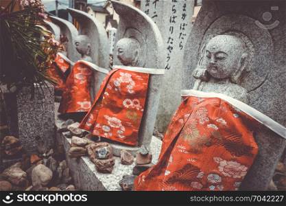 Jizo statues with red bibs in Arashiyama temple, Kyoto, Japan. Jizo statues in Arashiyama temple, Kyoto, Japan