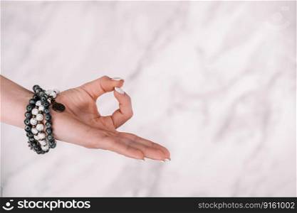 Jnana Gian mudra - Om on white background. Female hand with mala beads bracelet. Woman meditating, doing yoga. Om on white background. Female hand with mala beads bracelet. Woman meditating,