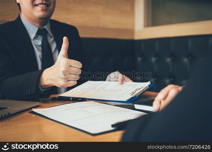 Job interviewer give a thumbs-up for job applications for new employee in the office room.
