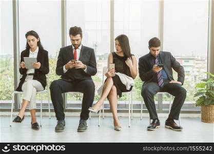 Job seekers and applicants waiting for interview on chairs in office. Job application and recruitment interview qualification concept.