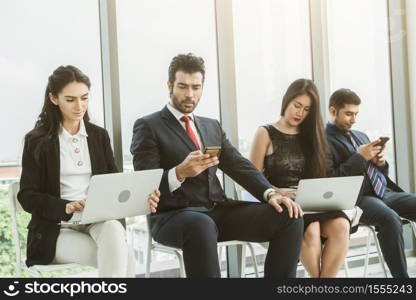 Job seekers and applicants waiting for interview on chairs in office. Job application and recruitment interview qualification concept.