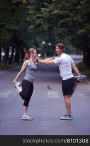 jogging couple warming up and stretching before running