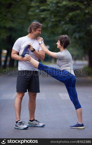 jogging couple warming up and stretching before running