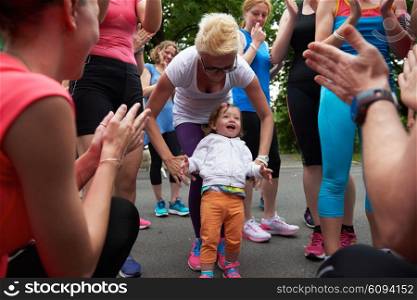 jogging people group, friends have fun with cute little baby gir, hug and stack hands together after training
