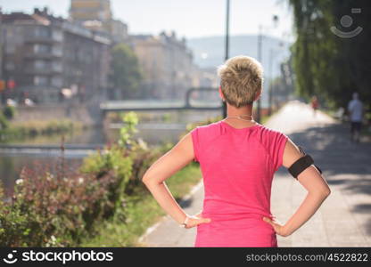 jogging woman setting music and running route on smart phone putting earphones before morning run