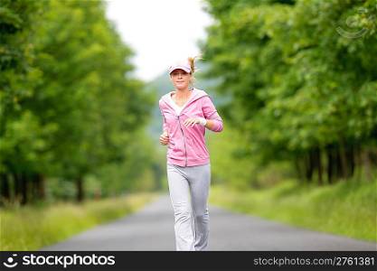Jogging young fit woman running park road in sportswear tracksuit