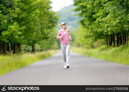 Jogging young fit woman running park road in sportswear tracksuit