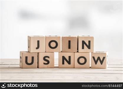 Join us now sign with wooden blocks on a table