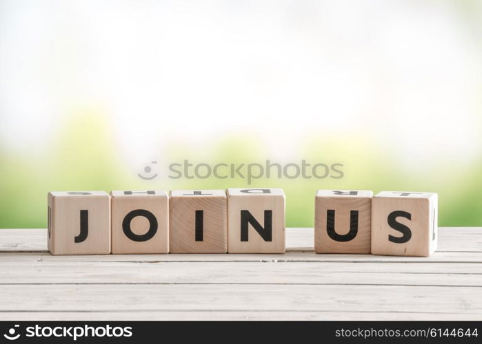 Join us sign on wooden cubes on green background