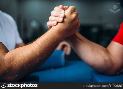 Joined male muscular hands at the table with pins, wrestling concept. Wrestle challenge. Ready, go. Joined male hands at the table, wrestling concept