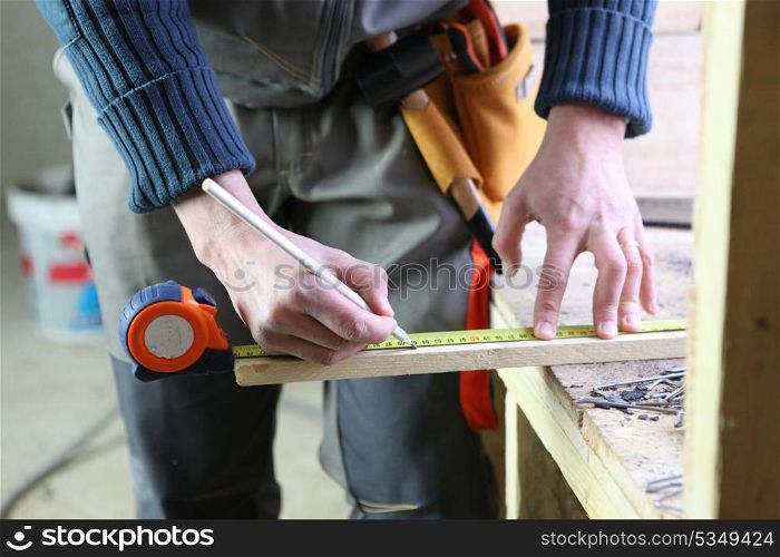 Joiner marking off plank of wood