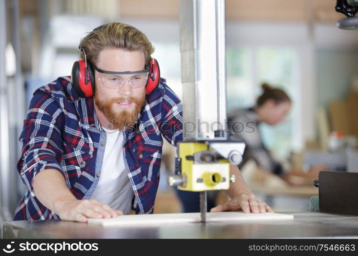 joiner wearing protection working on a wooden piece