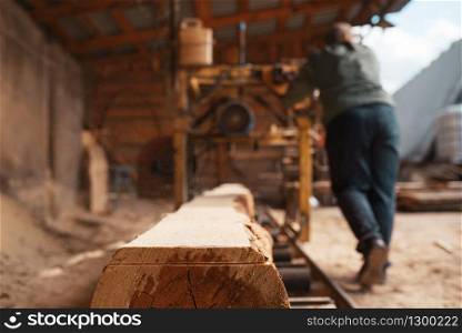 Joiner works on woodworking machine, lumber industry, carpentry. Wood processing on factory, forest sawing in lumberyard, lumbering. Joiner works on woodworking machine, lumbering