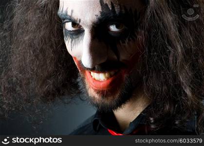 Joker personification with man in dark room
